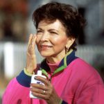 smiling woman in pink and blue shirt