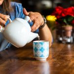 unknown person holding white ceramic kettle